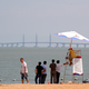 Visitors chat with a lifeguard on a beach as they look at the Zhuhai-Macau-Hong Kong Bridge in Zhuhai in south China’s Guangdong province.